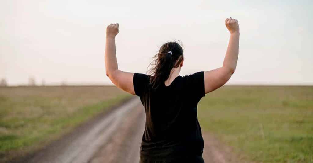 Woman celebrating rising hands to sky