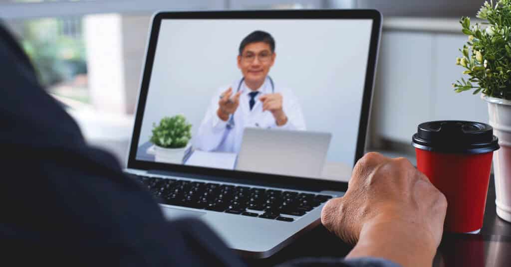 Doctor explaining to patient via laptop computer for telemedicine and medical online e-health consultation.